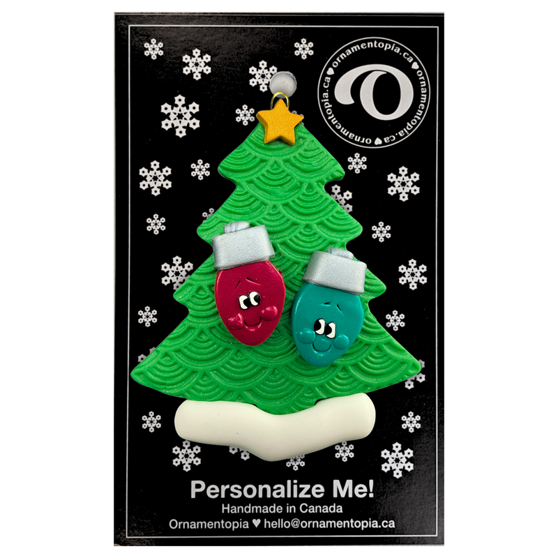 Christmas tree ornament decorated with 2 light bulbs with smiling faces, on display backing card.