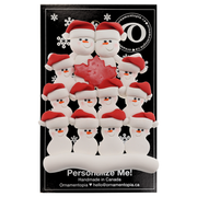 Family ornament with 12 white snowmen in red hats, gathered around a red maple leaf, on display backing card.