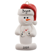 Ornament of white snowman in red hat holding several playing cards, personalized with name.