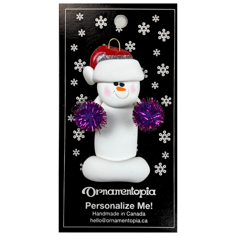 Ornament of white snowman in red hat holding purple cheerleader pom-poms, on display backing card.