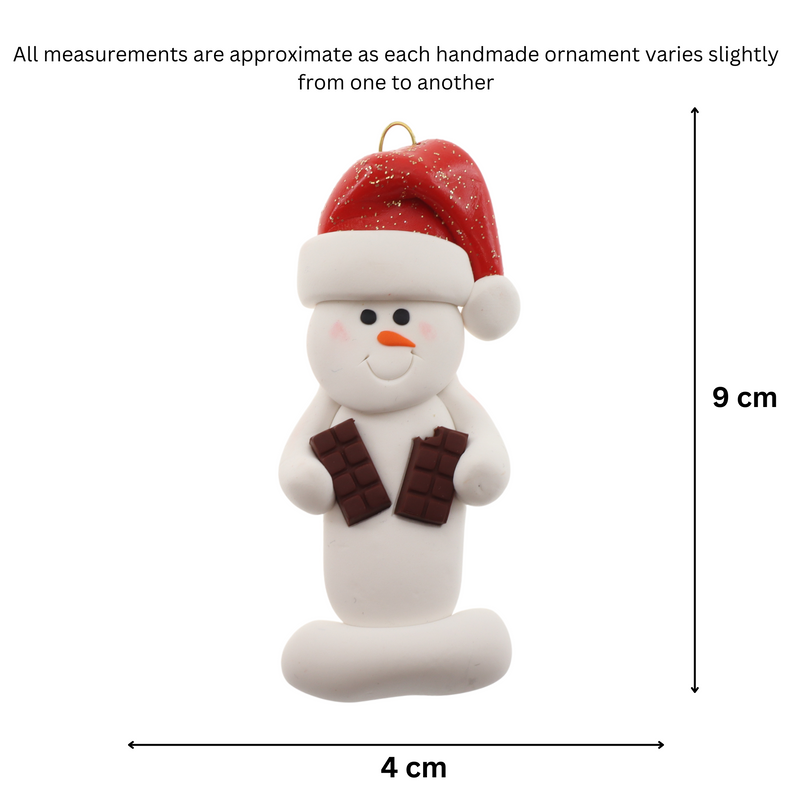 Ornament of white snowman in red hat holding two chocolate bars, graphed to show size (4x9cm).