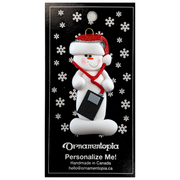 Ornament of white snowman in red hat holding an i-pod with headphones, on display backing card.