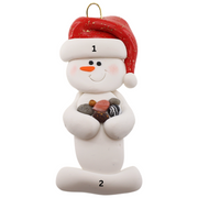 Ornament of white snowman in red hat holding several small rocks, numbered 1-2 for personalization.