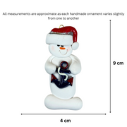 Ornament of white snowman in red hat holding a plastic anchor, graphed to show size (4x9cm).