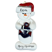 Ornament of white snowman in red hat holding a plastic anchor, personalized with name.