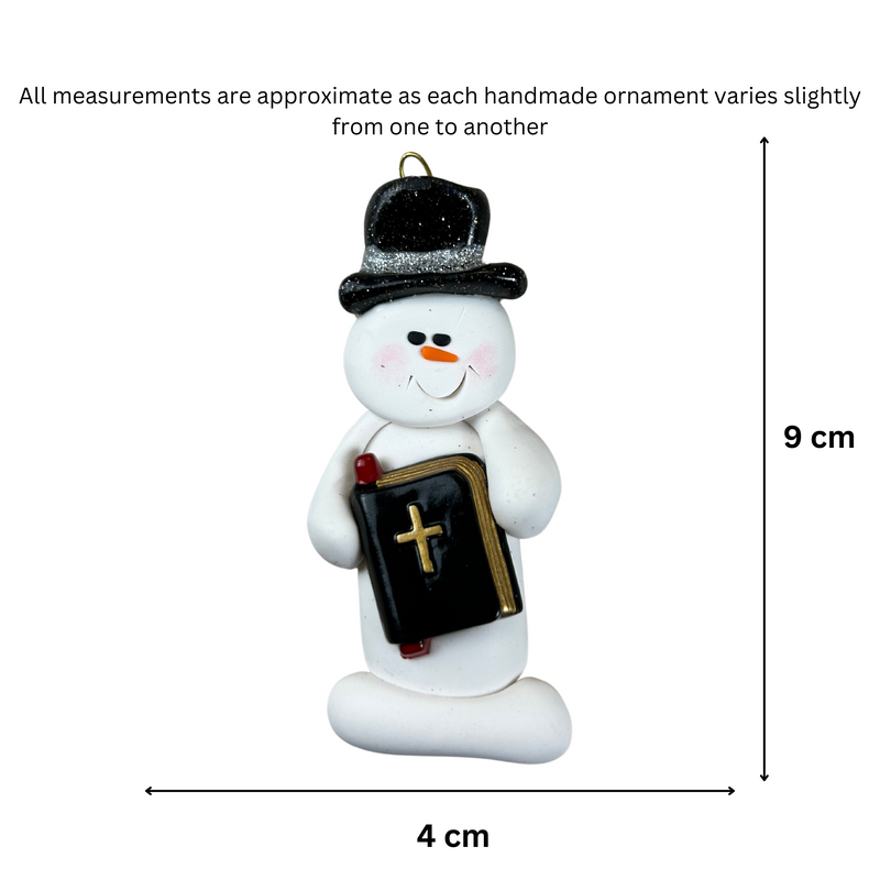 Ornament of white snowman in black top hat, holding a Bible, graphed to show size (4x9cm).