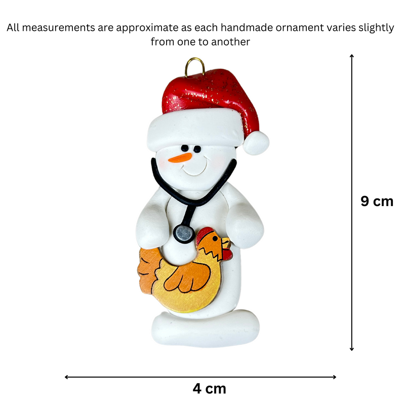 Ornament of white snowman in red hat holding chicken and stethoscope, graphed to show size (4x9cm).