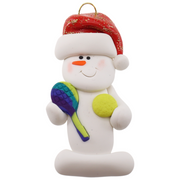Ornament of white snowman in red hat holding a tennis paddle and ball.