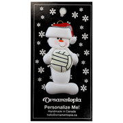 Ornament of white snowman in red hat holding a volleyball, on display backing card.