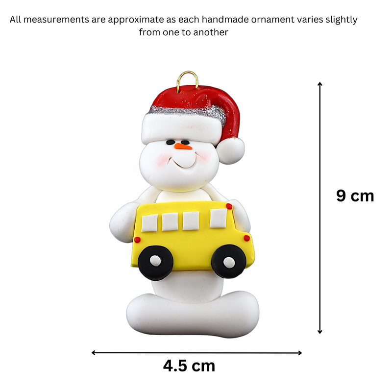 Ornament of white snowman in red hat holding a yellow school bus, graphed to show size (4.5x9cm).
