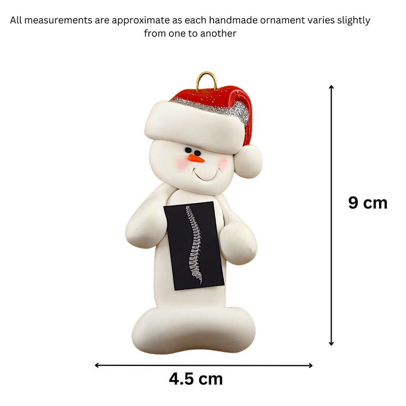Ornament of white snowman in red hat holding black and white x-ray of a spine, graphed to show size (4.5x9cm).