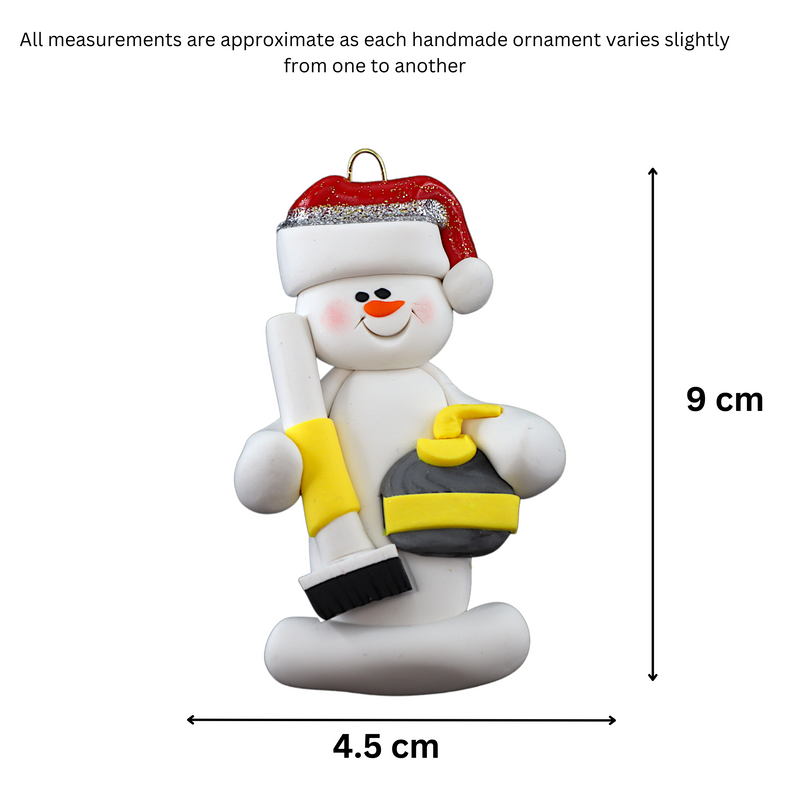Ornament of white snowman in red hat holding yellow curling stone and broom, graphed to show size (4.5x9cm).
