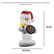 Ornament of white snowman in red hat holding dart board and one dart, graphed to show size (4.5x9cm).