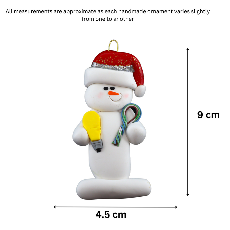 Ornament of white snowman in red hat holding a lightbulb and coil of wire, graphed to show size (4.5x9cm).