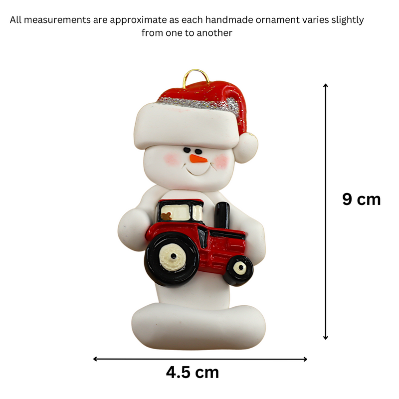 Ornament of white snowman in red hat holding a red tractor, graphed to show size (4.5x9cm).