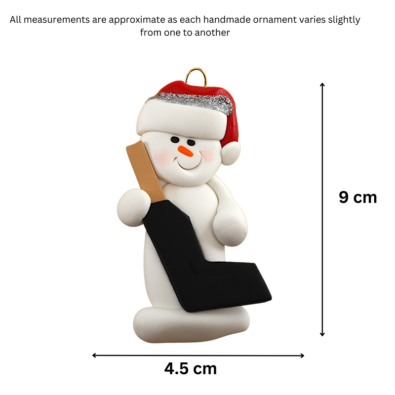Ornament of white snowman in red hat holding a goalie stick, graphed to show size (4.5x9cm).