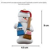 Ornament of white snowman in red hat holding a broom and bottle of cleaning solution, graphed to show size (4.5x9cm).
