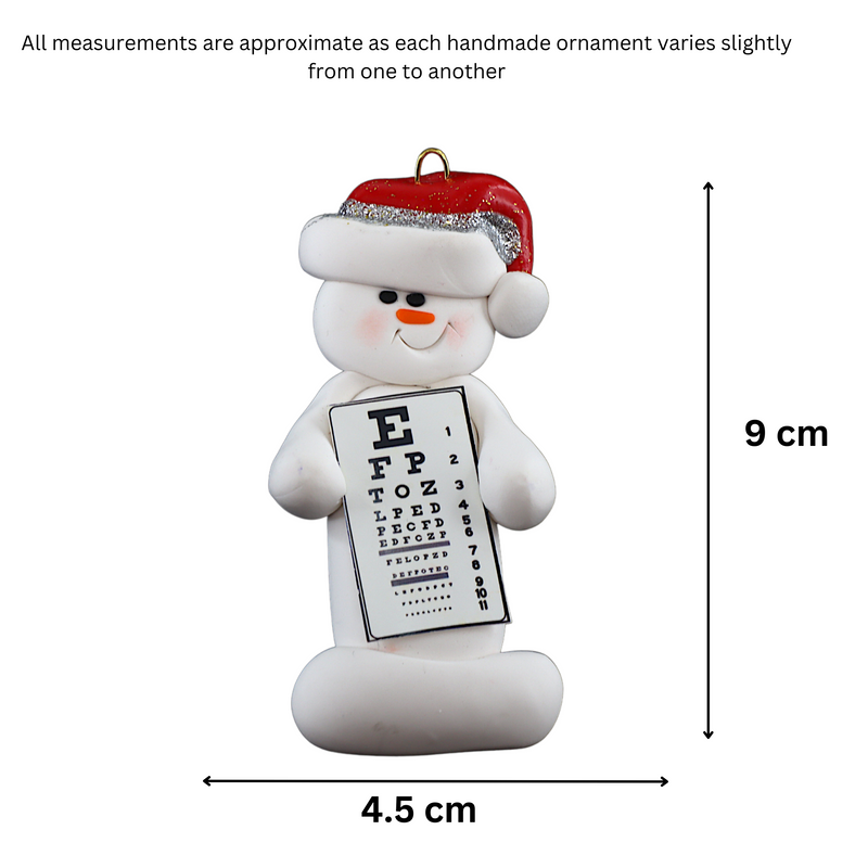 Ornament of white snowman in red hat holding an eye chart, graphed to show size (4.5x9cm).