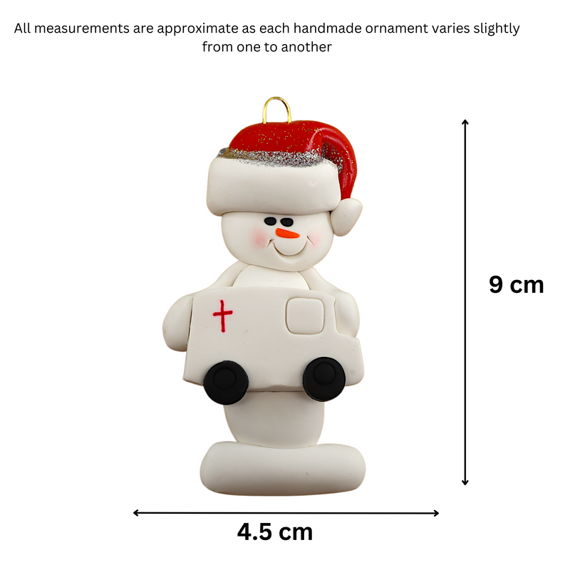 Ornament of white snowman in red hat holding a white ambulance, graphed to show size (4.5x9cm).