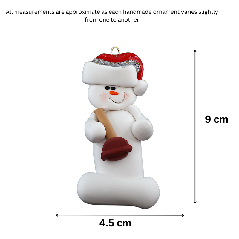 Ornament of white snowman in red hat holding a toilet plunger, graphed to show size (4.5x9cm).