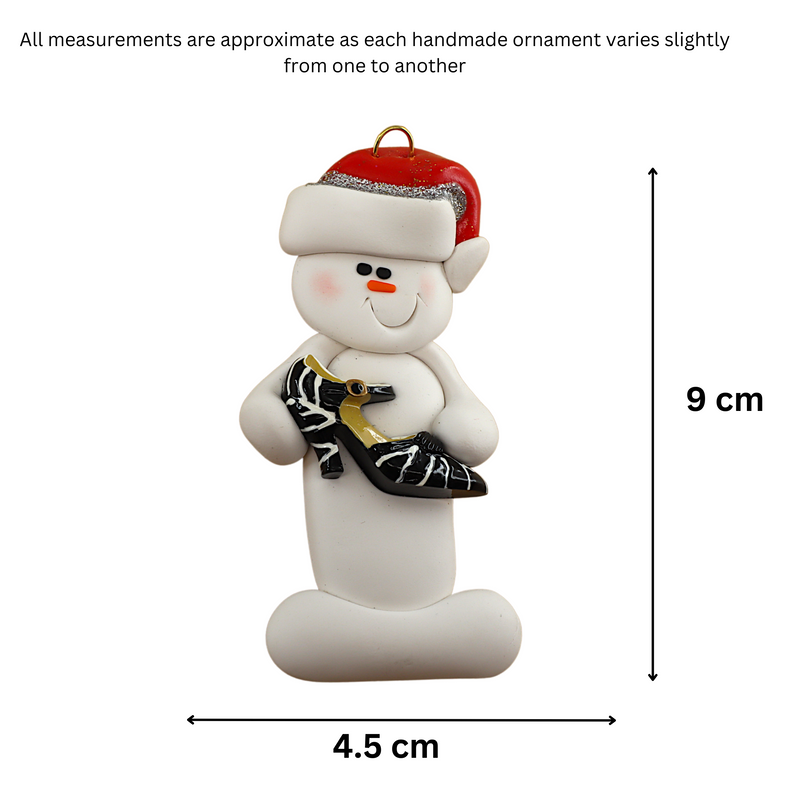Ornament of white snowman in red hat holding a fancy shoe, graphed to show size (4.5x9cm).
