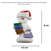 Ornament of white snowman in red hat holding a purse and various bank cards, graphed to show size (4.5x9cm).