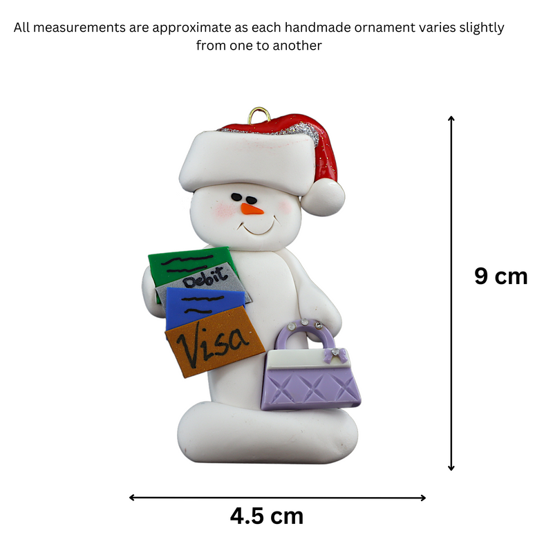 Ornament of white snowman in red hat holding a purse and various bank cards, graphed to show size (4.5x9cm).