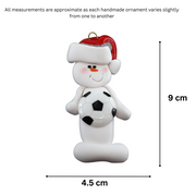 Ornament of white snowman in red hat holding a soccer ball, graphed to show size (4.5x9cm).