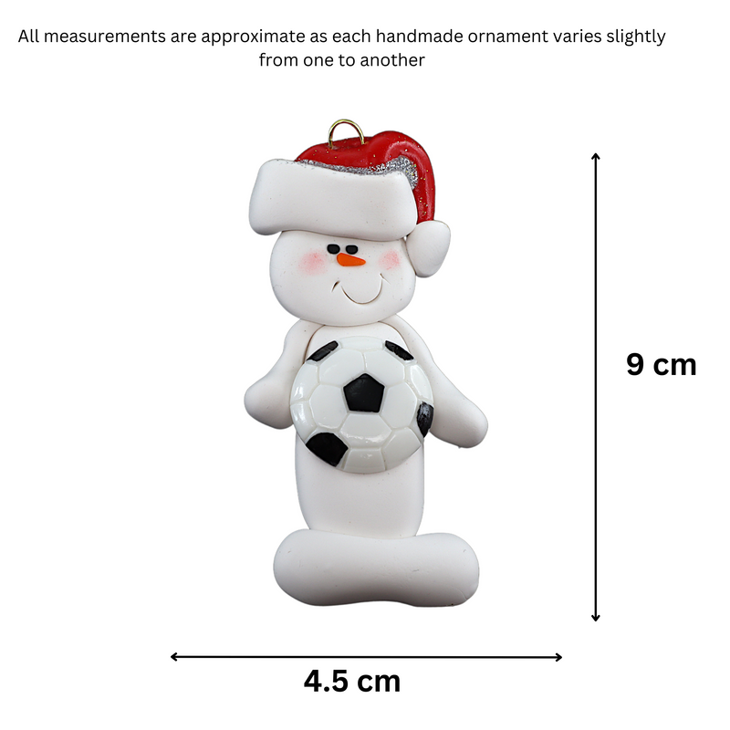 Ornament of white snowman in red hat holding a soccer ball, graphed to show size (4.5x9cm).