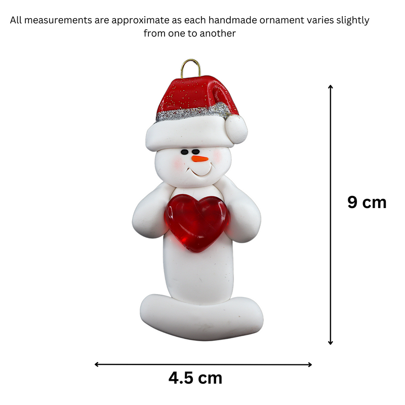 Ornament of white snowman in red hat holding a shiny red heart, graphed to show size (4.5x9cm).