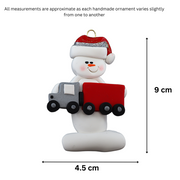 Ornament of white snowman in red hat holding a red semi truck, graphed to show size (4.5x9cm).
