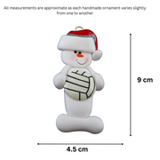 Ornament of white snowman in red hat holding a volleyball, graphed to show size (4.5x9cm).