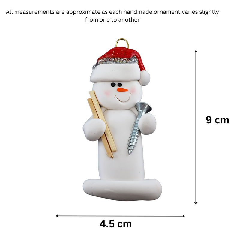 Ornament of white snowman in red hat holding a piece of wood and a screw, graphed to show size (4.5x9cm).