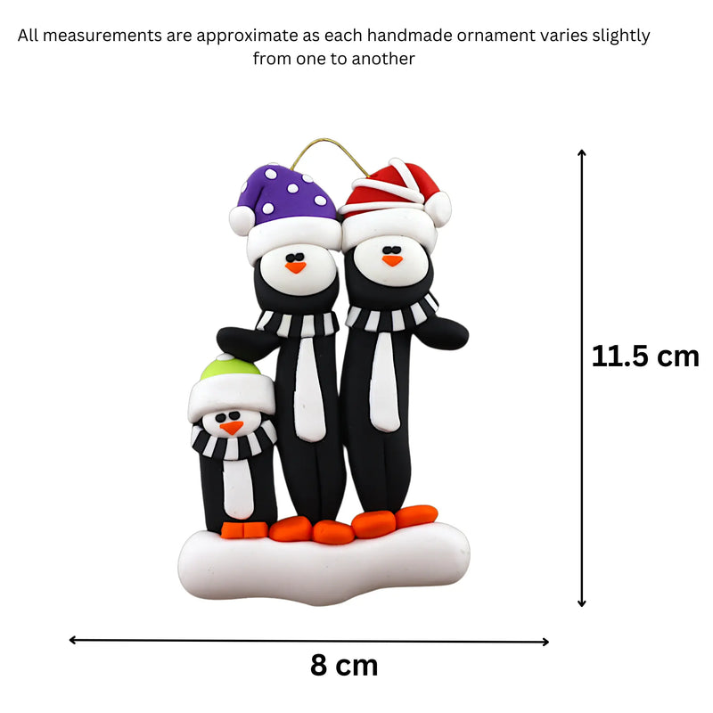 Family ornament with 3 black and white penguins in colourful festive hats, graphed to show size (8x11.5cm).