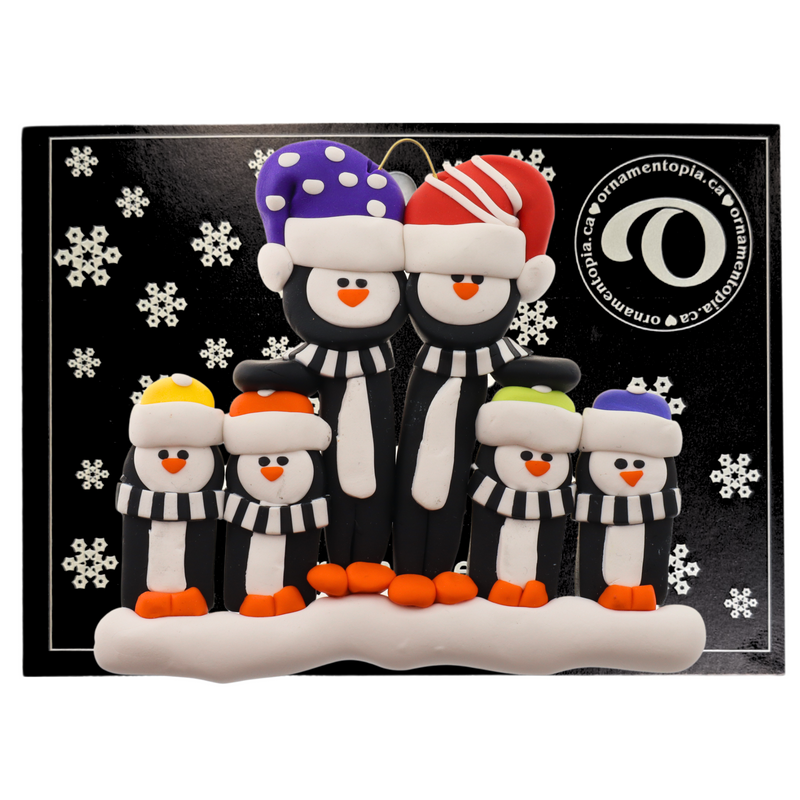 Family ornament with 6 black and white penguins in colourful festive hats, on display backing card.