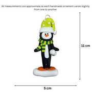 Penguin wearing green hat and scarf ornament, graphed to show size (5x11cm).