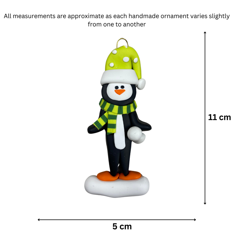Penguin wearing green hat and scarf ornament, graphed to show size (5x11cm).
