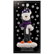 Penguin wearing purple hat and scarf ornament, on display backing card.