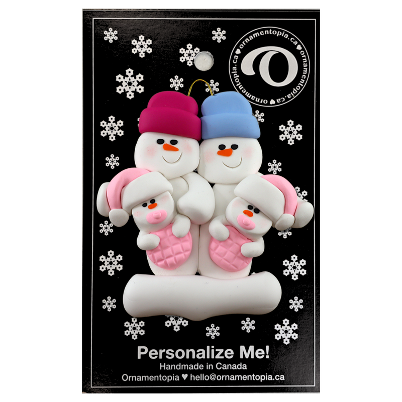 Family ornament with 2 large and 2 infant snowmen in pink, on display backing card.