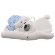 Ornament of white sleeping polar bear baby in a blue hat, numbered 1-2 for personalization.
