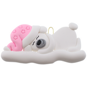 Ornament of white sleeping polar bear baby in a pink hat.