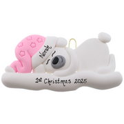 Ornament of white sleeping polar bear baby in a pink hat, personalized with name.