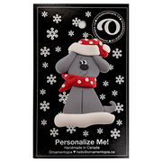 Ornament of grey dog in a red and white polka dot Christmas hat and scarf, on display backing card.