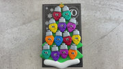 Christmas tree ornament decorated with 13 light bulbs with smiling faces, shown on backing card and decorated Christmas tree.