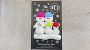 Family ornament with 4 snowmen in bright hats, one pregnant, shown on backing card and Christmas tree.