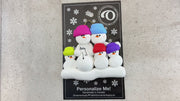 Family ornament with 5 snowmen in bright hats, one pregnant, shown on backing card and Christmas tree.