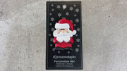 Santa with red festive hat ornament, shown on backing card and Christmas tree.