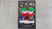 Vibrant fireplace ornament with holly and presents, displaying 6 red stockings, shown on backing card and Christmas tree.