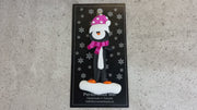 Penguin wearing pink hat and scarf ornament, shown on backing card and Christmas tree.