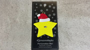 Yellow star in red Christmas hat ornament, shown on backing card and Christmas tree.